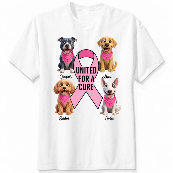 A white short-sleeve crewneck t-shirt featuring a graphic print of dogs wearing pink bandanas around a large pink ribbon with the text 'UNITED FOR A CURE'.