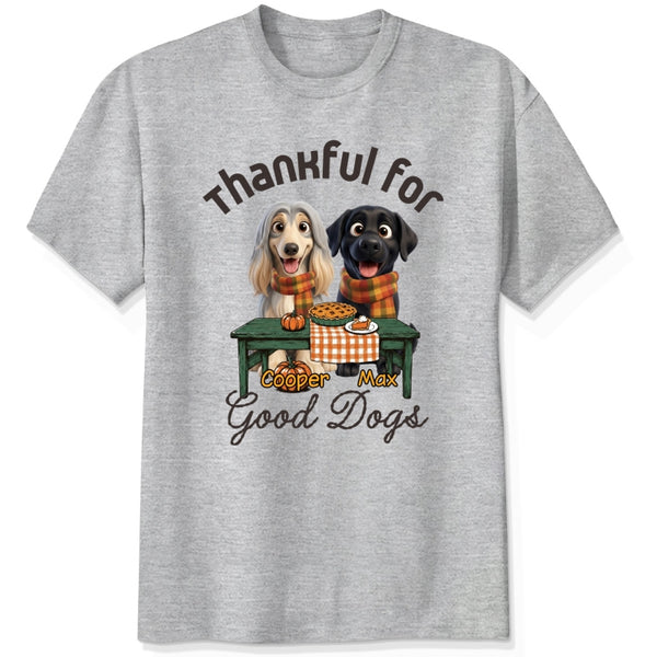 An ash gray short-sleeve crewneck t-shirt featuring a graphic print of custom dogs sitting at a table with autumn food, with the text 'Thankful for Good Dogs' and custom dog's names written around the illustration.